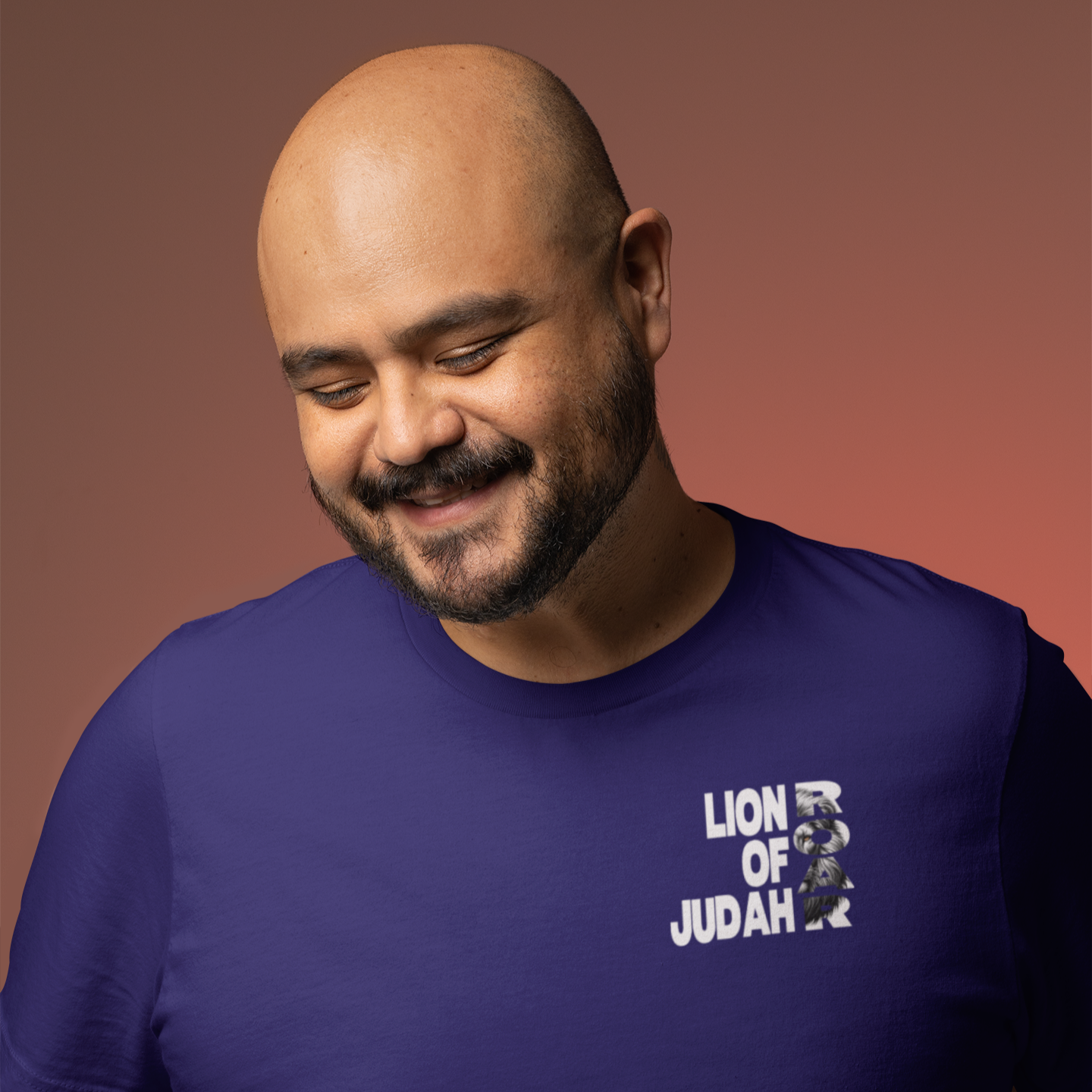 Man wearing a purple t-shirt with 'Lion of Judah' text and logo on a brown background